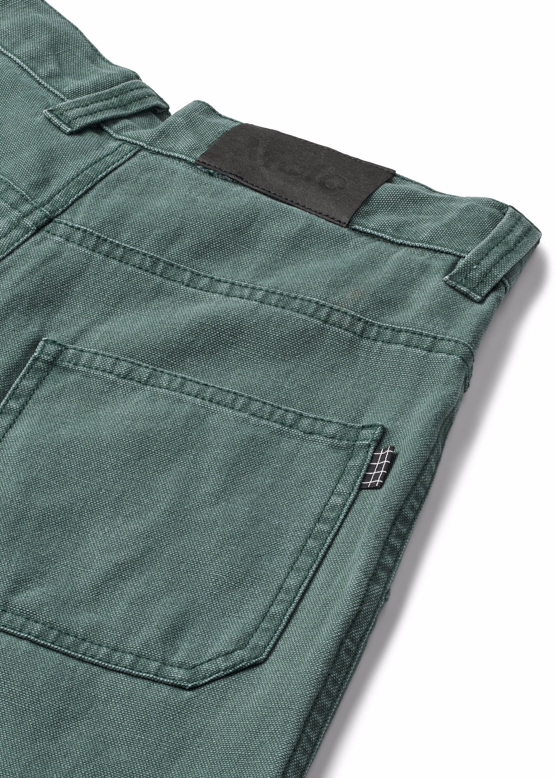 Close-up of green pants with a pocket and label on a white background