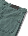 Close-up of green pants with a pocket and label on a white background