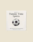 Baby's Tummy Time Sports baby board book with a white cover, black text, and a black and white soccer ball illustration, set against a solid beige background.