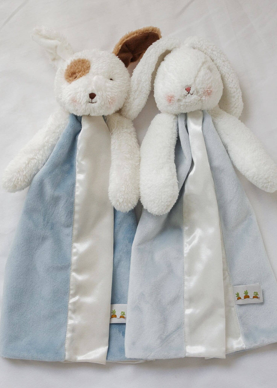 Two plush toys with blue and white scarves on a light background