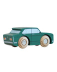 Green toy car with wooden wheels on a beige background