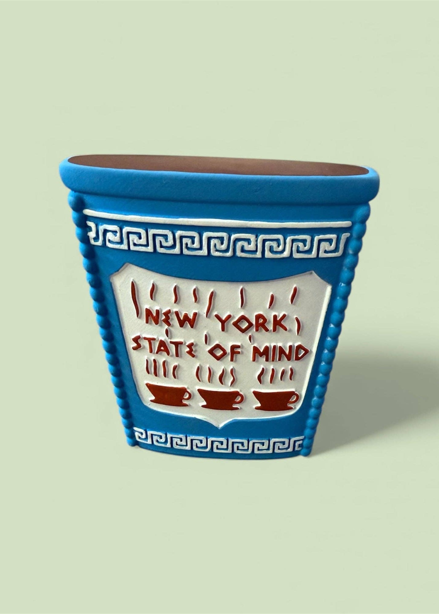 Blue ceramic planter with 'New York State of Mind' text on a light green background