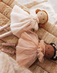 Two dolls with tulle dresses on a textured surface