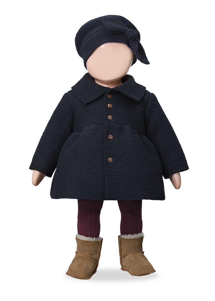 Doll wearing a dark coat, hat, and boots on a white background