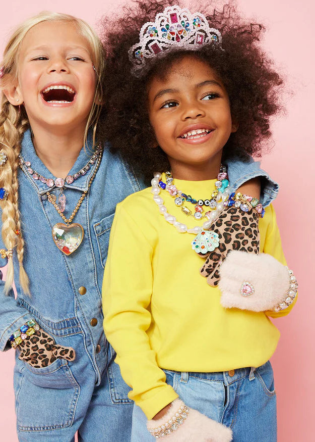 Two children wearing colorful jewelry against a pink background