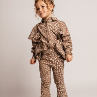 Child wearing a brown patterned outfit on a plain background