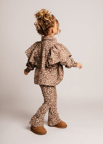 Child wearing a patterned outfit on a plain background