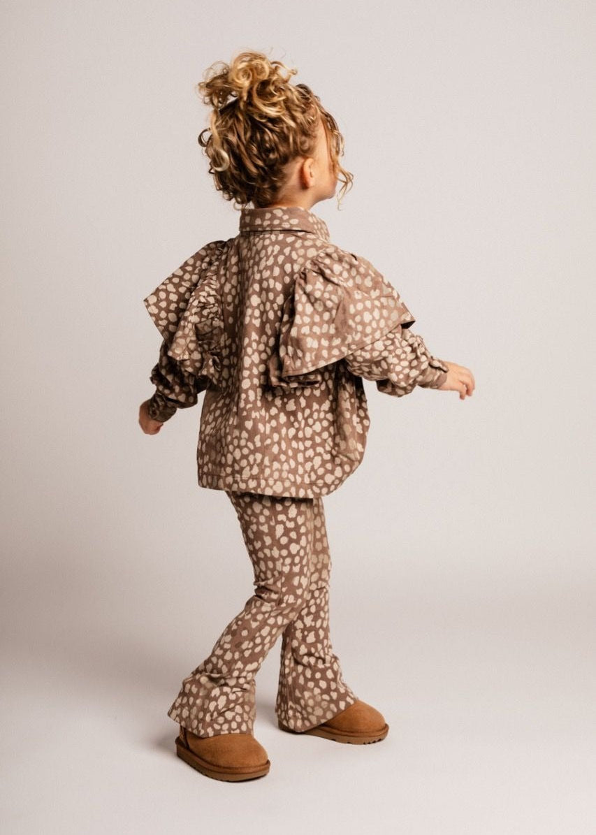 Child wearing a patterned outfit on a plain background