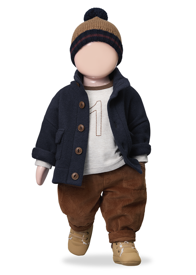 Doll wearing a navy coat, brown pants, and a beanie on a white background