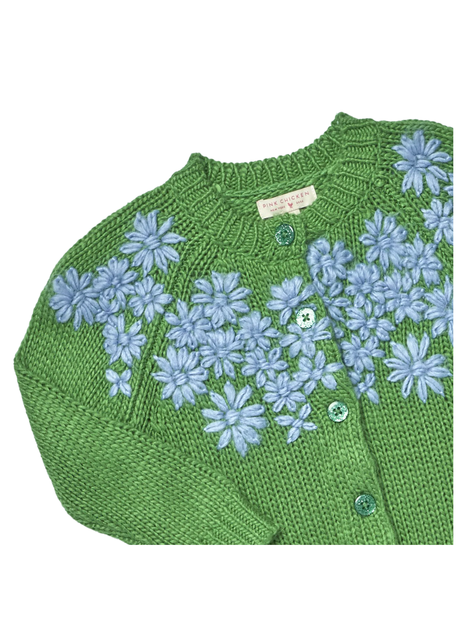 A close-up of a green knitted cardigan with light blue floral embroidery and green buttons, showing a pink and white brand label that reads 'PINK &amp; DUFFLE'.