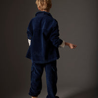 Person wearing a dark blue outfit against a gray background