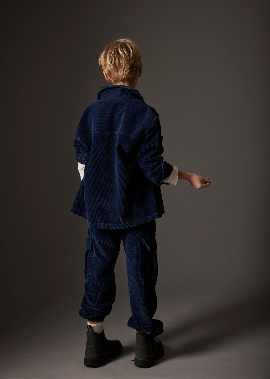 Person wearing a dark blue outfit against a gray background