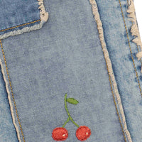 Embroidered cherries on a denim fabric
