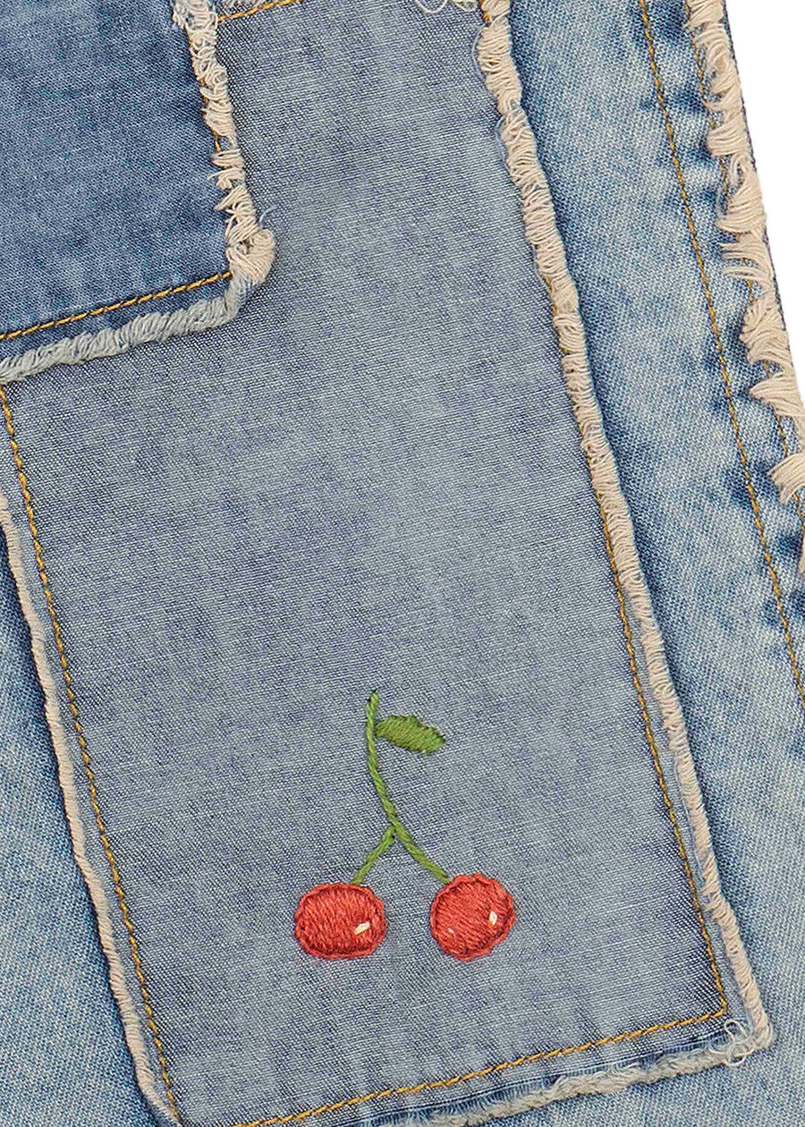 Embroidered cherries on a denim fabric