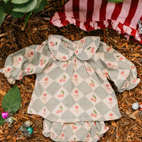 Children's checkered dress with floral pattern on a natural background
