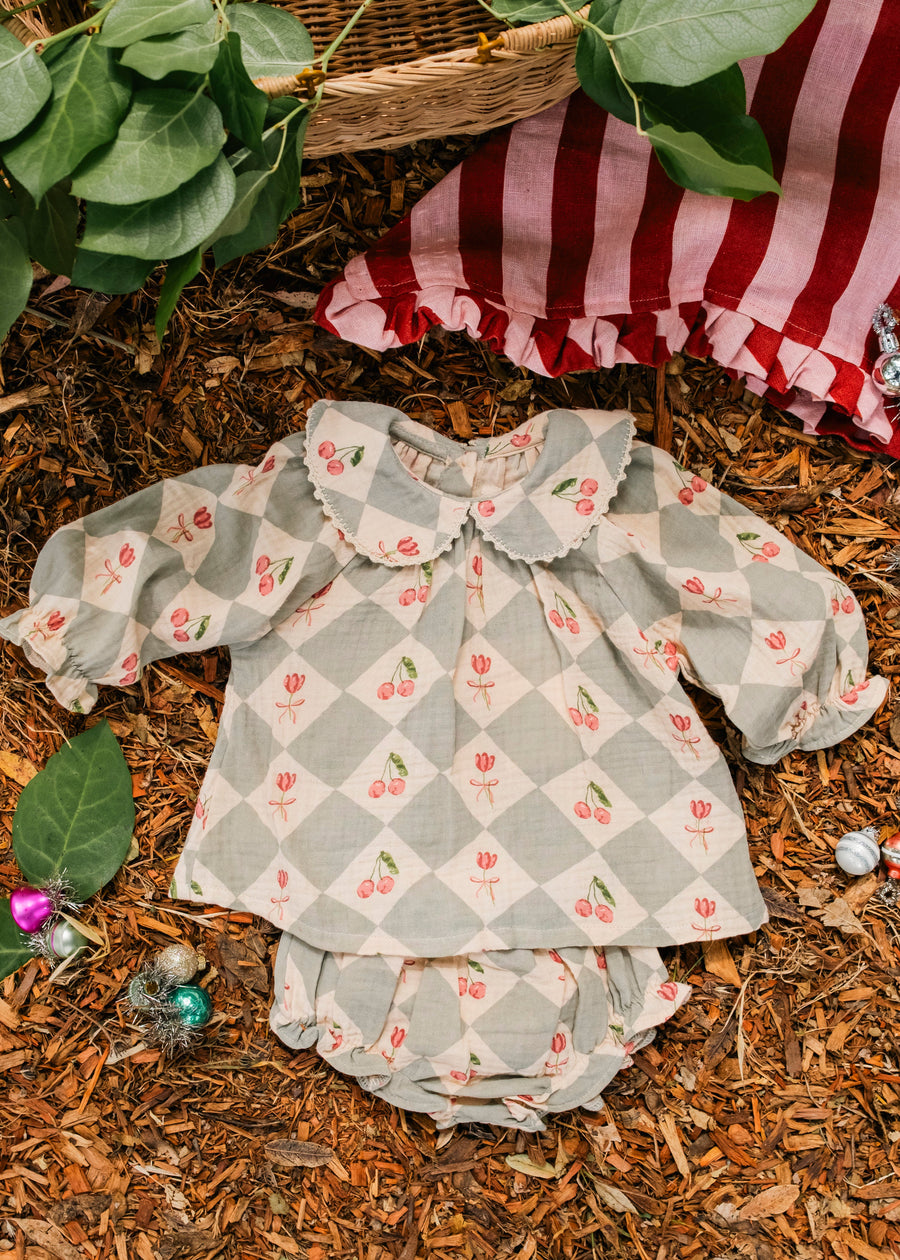 Children's checkered dress with floral pattern on a natural background