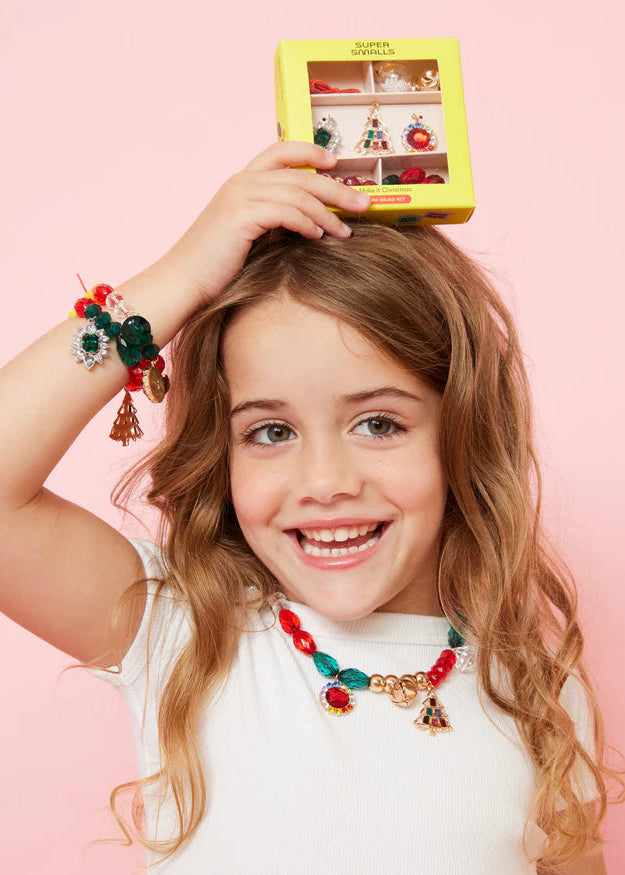 Young girl wearing colorful jewelry with a pink background