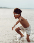 Child playing in shallow water at the beach
