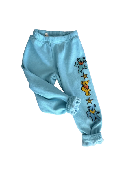 Light blue sweatpants featuring embroidered Grateful Dead-style bears and stars down one leg, shown on a plain white background.
