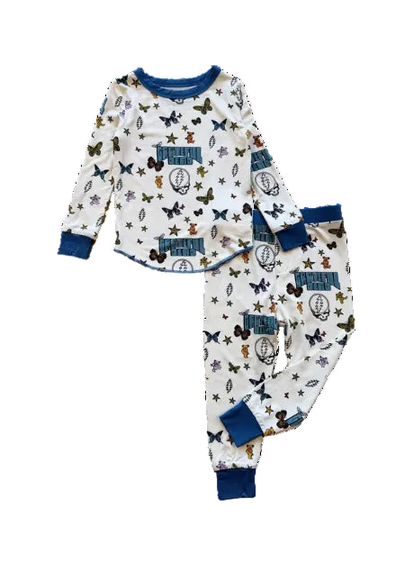 A two-piece long-sleeve pajama set featuring an off-white base printed with blue, brown, and purple butterflies, footballs, stars, and 'Troyden' logos, finished with solid blue cuffs and collar.