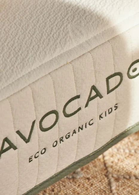 Close-up of a product with 'Avocado Eco Organic Kids' branding on a textured surface.
