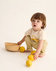 Child playing with lemons and a basket on a white background