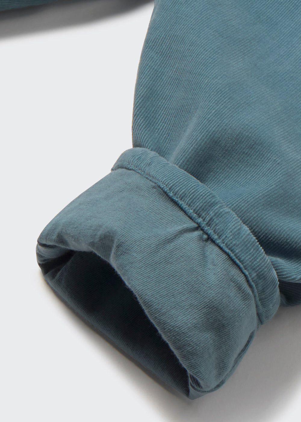 Close-up of a blue fabric edge on a light gray background