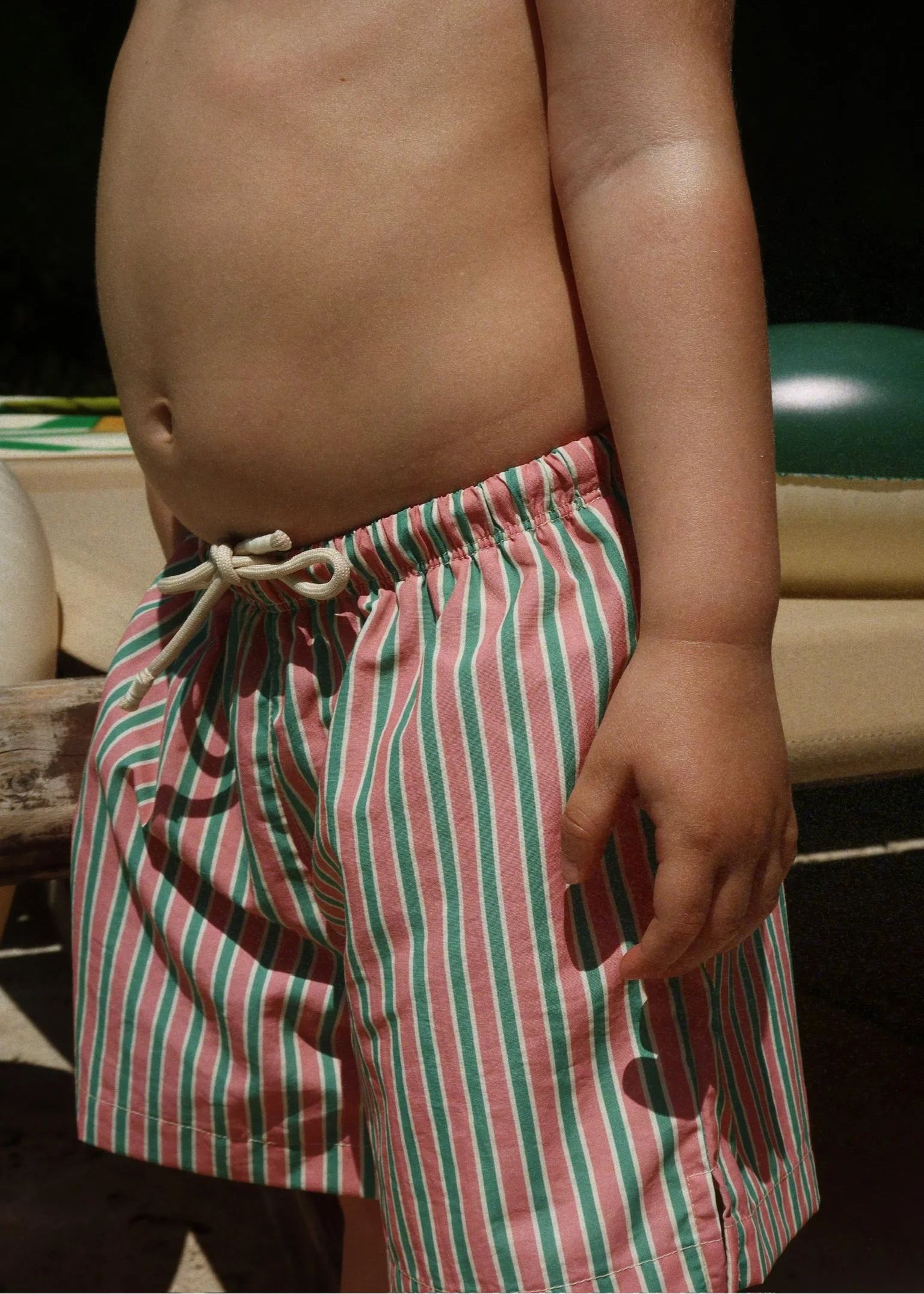 Person wearing red and green striped shorts with a blurred background