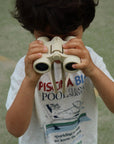 Child holding binoculars with a vintage pool service t-shirt in the background