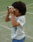 Child holding binoculars on a sports field