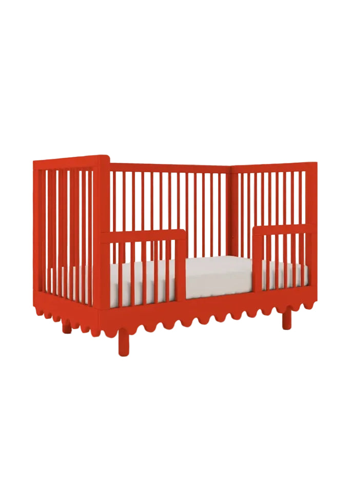 Red crib with white bedding on a white background