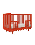 Red crib with white bedding on a white background