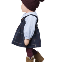Child's outfit with a knitted hat, plaid dress, and brown boots on a white background