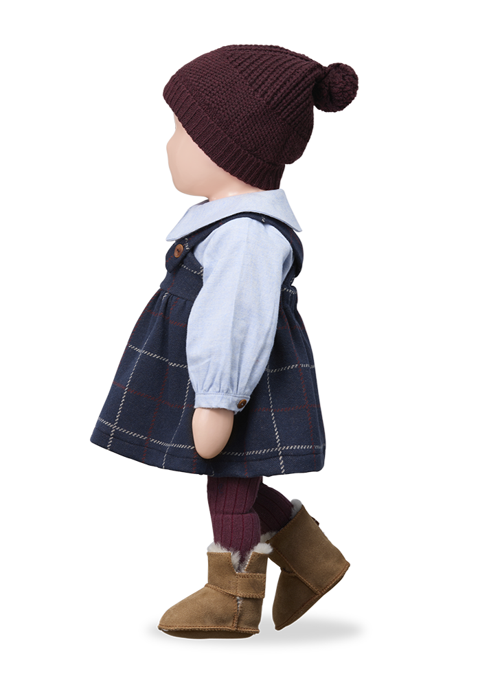 Child's outfit with a knitted hat, plaid dress, and brown boots on a white background