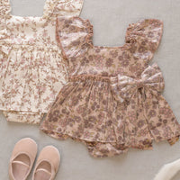 Floral baby outfit with top and shorts on a light gray background