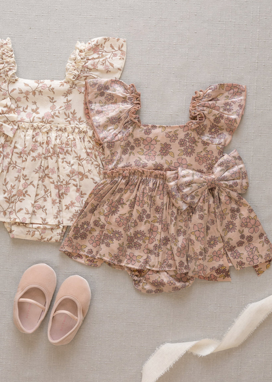 Floral baby outfit with top and shorts on a light gray background
