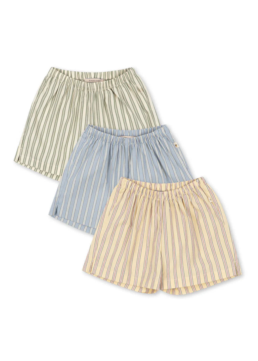 Three striped skirts in green, blue, and beige on a white background