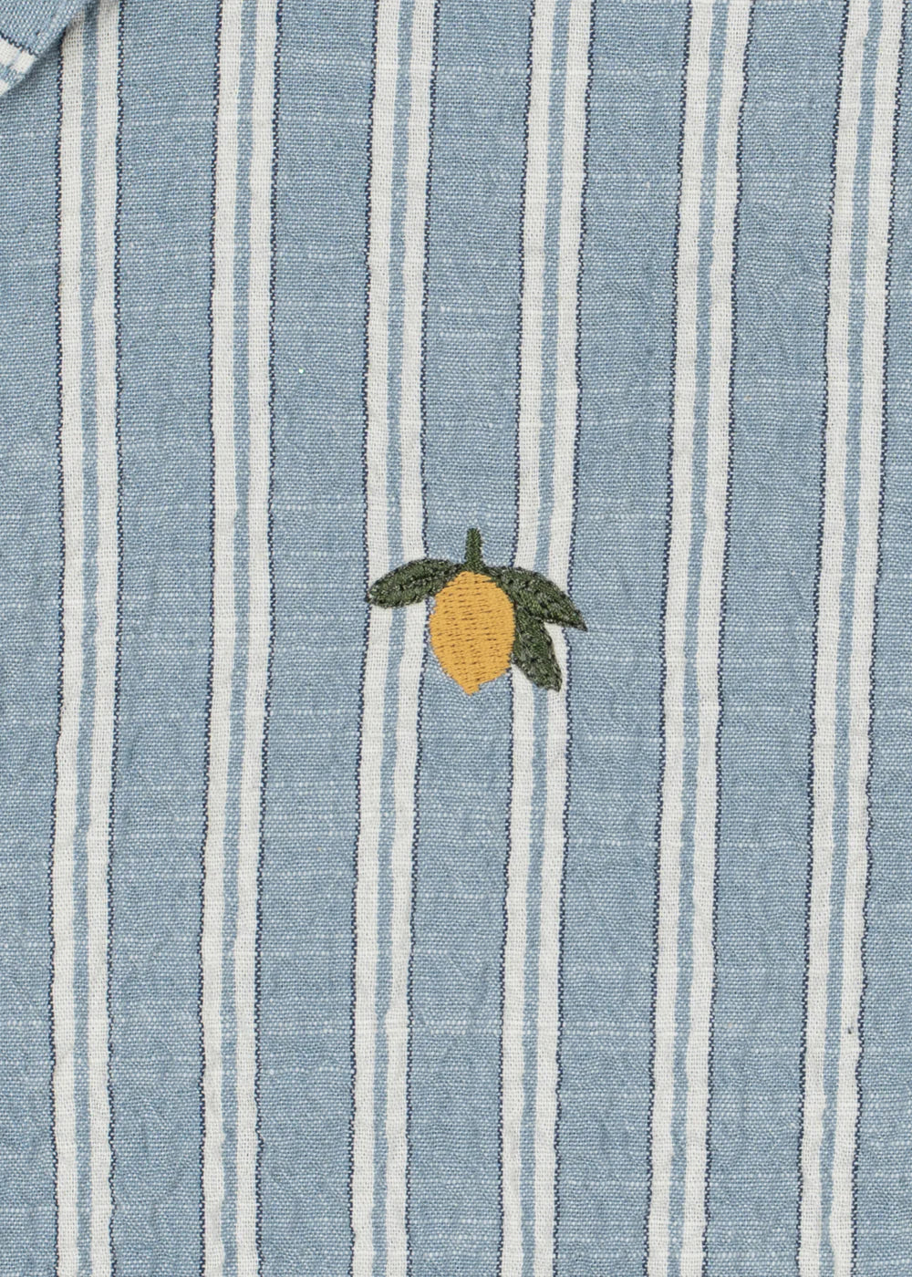 Blue and white striped fabric with a lemon embroidered on it