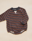 A baby long-sleeve romper with horizontal rust brown and dark gray stripes, featuring a small white V-shaped detail at the neckline and a soft fleece lining at the leg openings, laid flat on a light beige background.