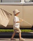 Child holding a fishing net and rod in front of a vintage van