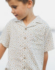 Child wearing a patterned shirt with a blurred background