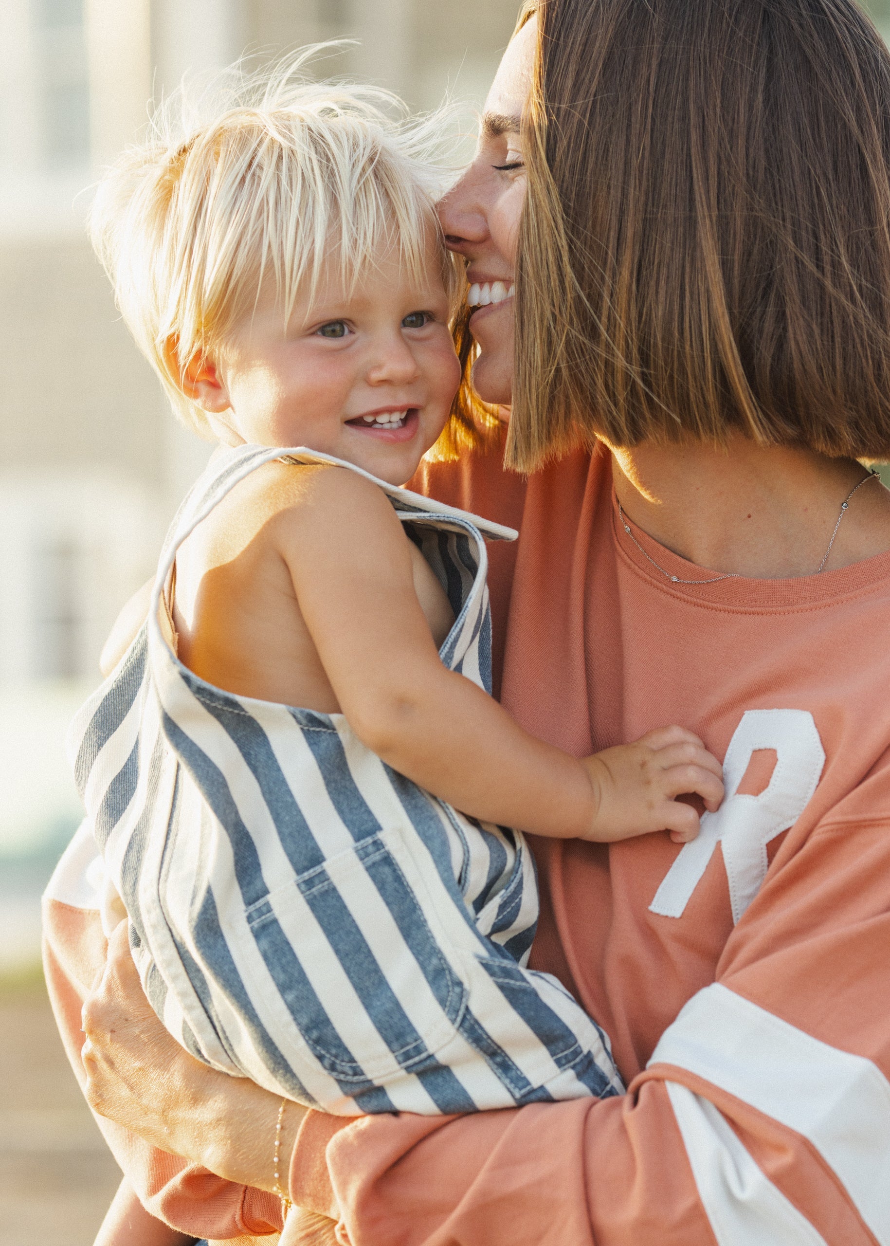 Woman holding a child outdoors, both smiling