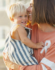 Woman holding a child outdoors, both smiling