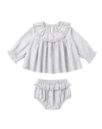 A baby girl's two-piece outfit set featuring a long-sleeve blouse and matching bloomers. The set is made of a light gray and white micro-patterned fabric with ruffle details on the collar, cuffs, and leg bands.