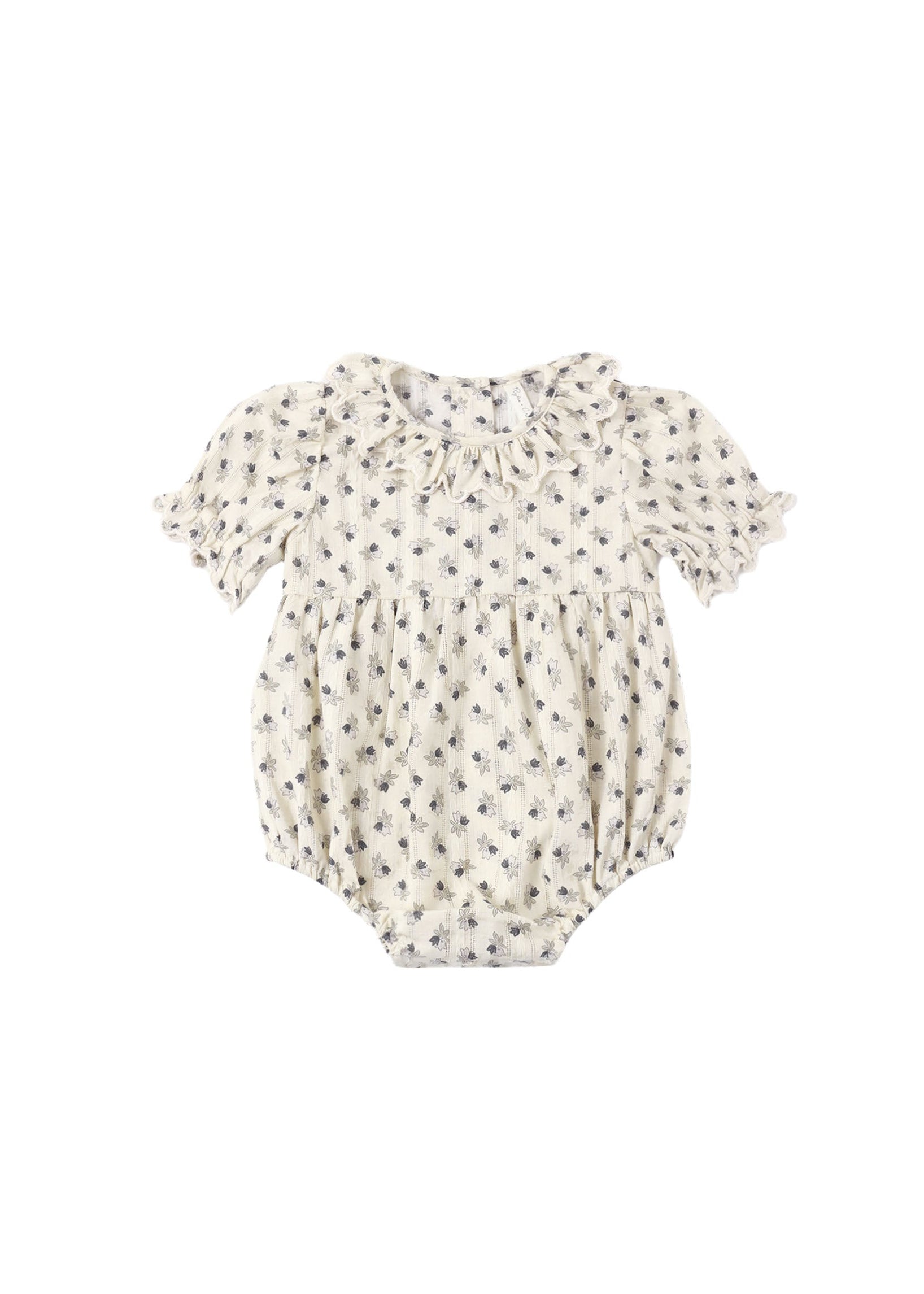 A baby short-sleeve romper in cream with a small dark floral print, featuring a ruffled collar and tie detail, shown flat on a white background.