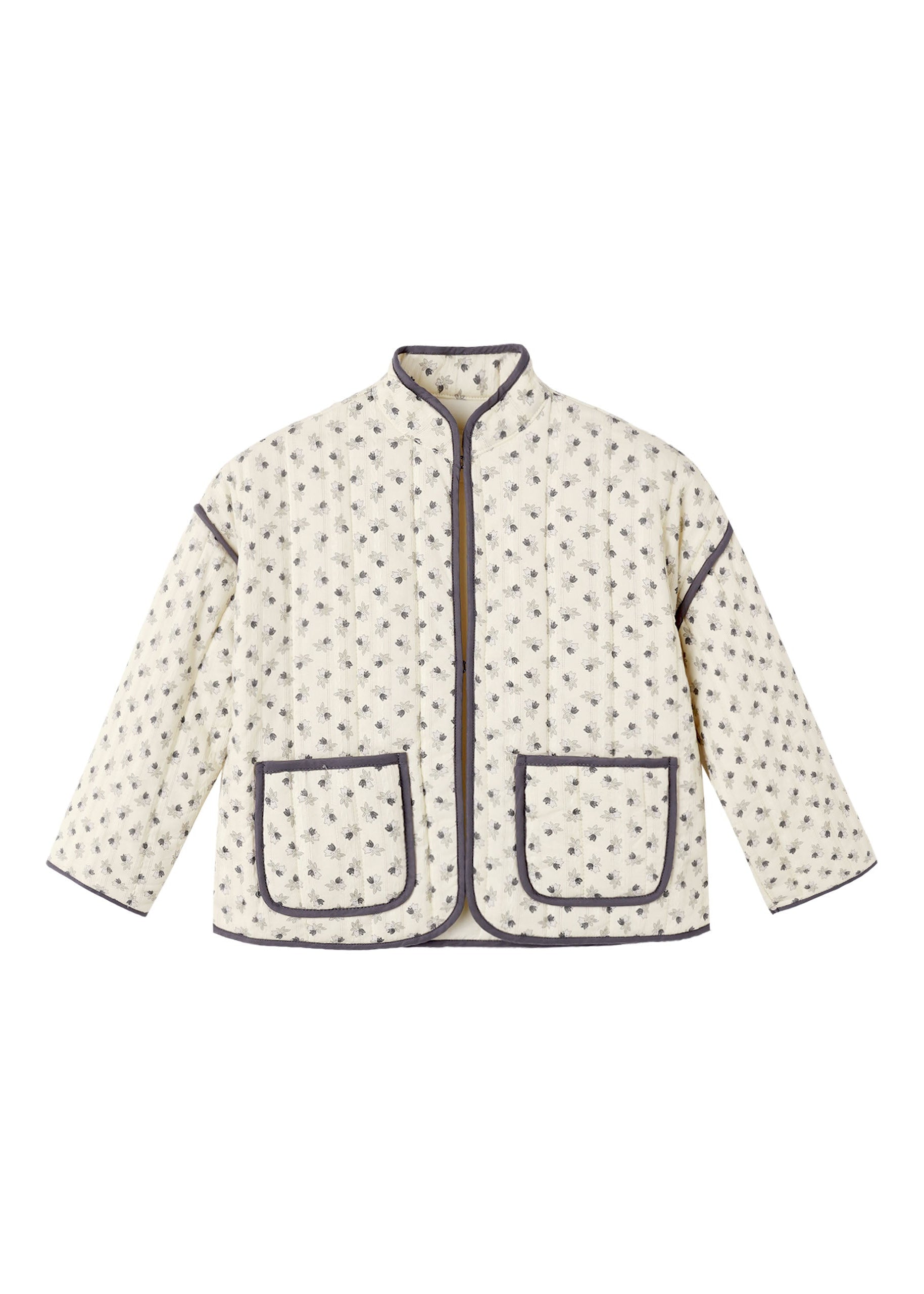 A cream-colored quilted jacket with a small dark floral pattern, featuring dark gray piping and two front patch pockets, shown flat on a white background.