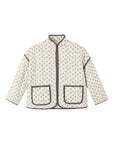 A cream-colored quilted jacket with a small dark floral pattern, featuring dark gray piping and two front patch pockets, shown flat on a white background.