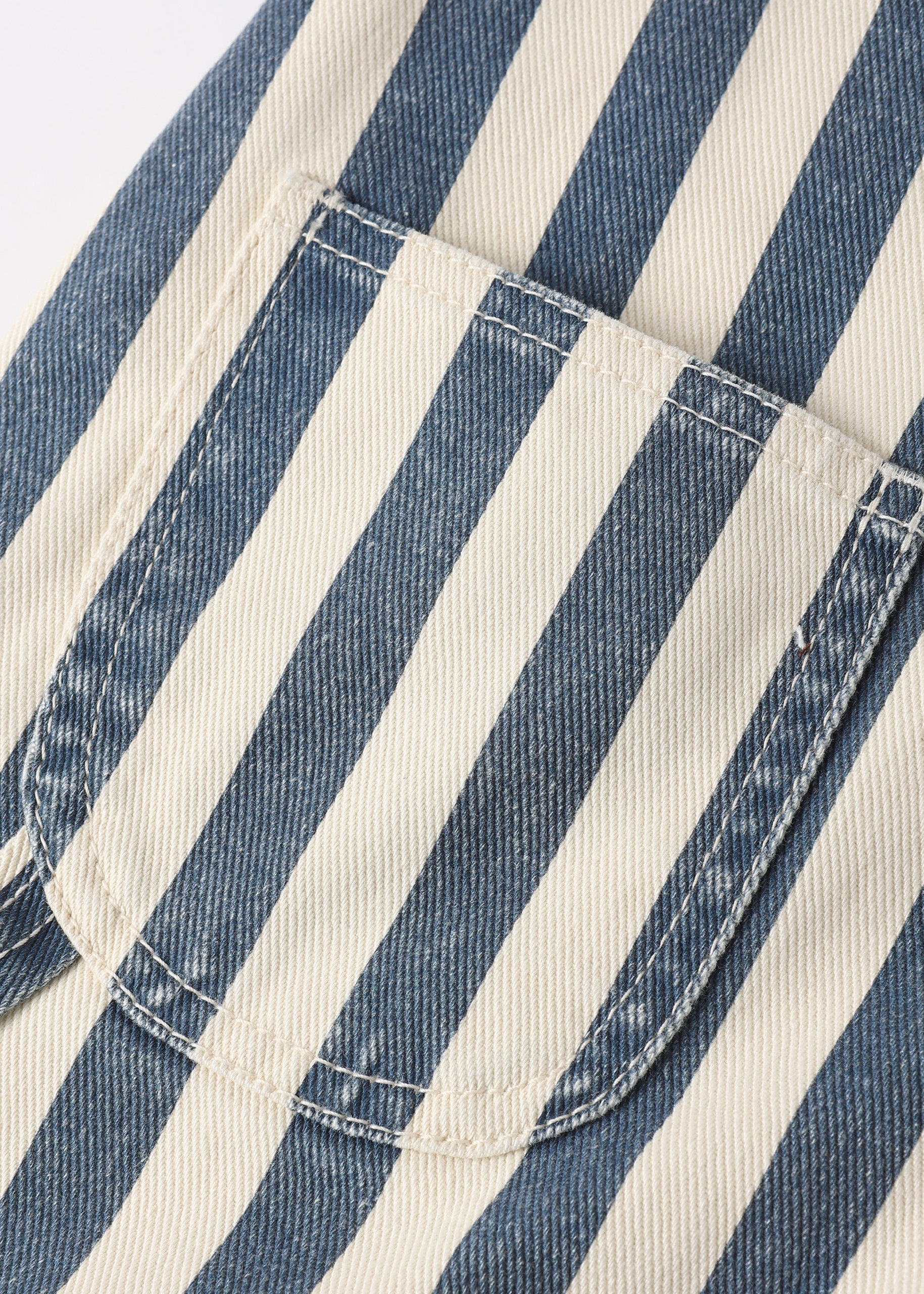 Close-up of blue and white striped fabric with a pocket detail.