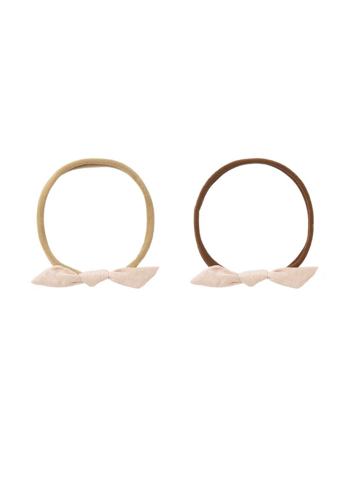 Two elastic hair ties with fabric bow accents, shown side by side on a plain white background. One hair tie is a light tan color with a pale pink bow, and the other is a medium brown with a light pink bow.