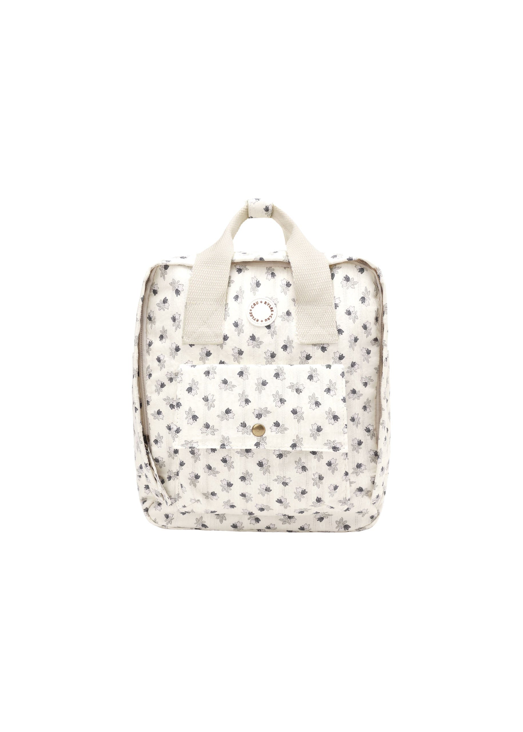 A small cream-colored backpack with a delicate black floral print, featuring top handles and a front pocket, shown against a plain white background.